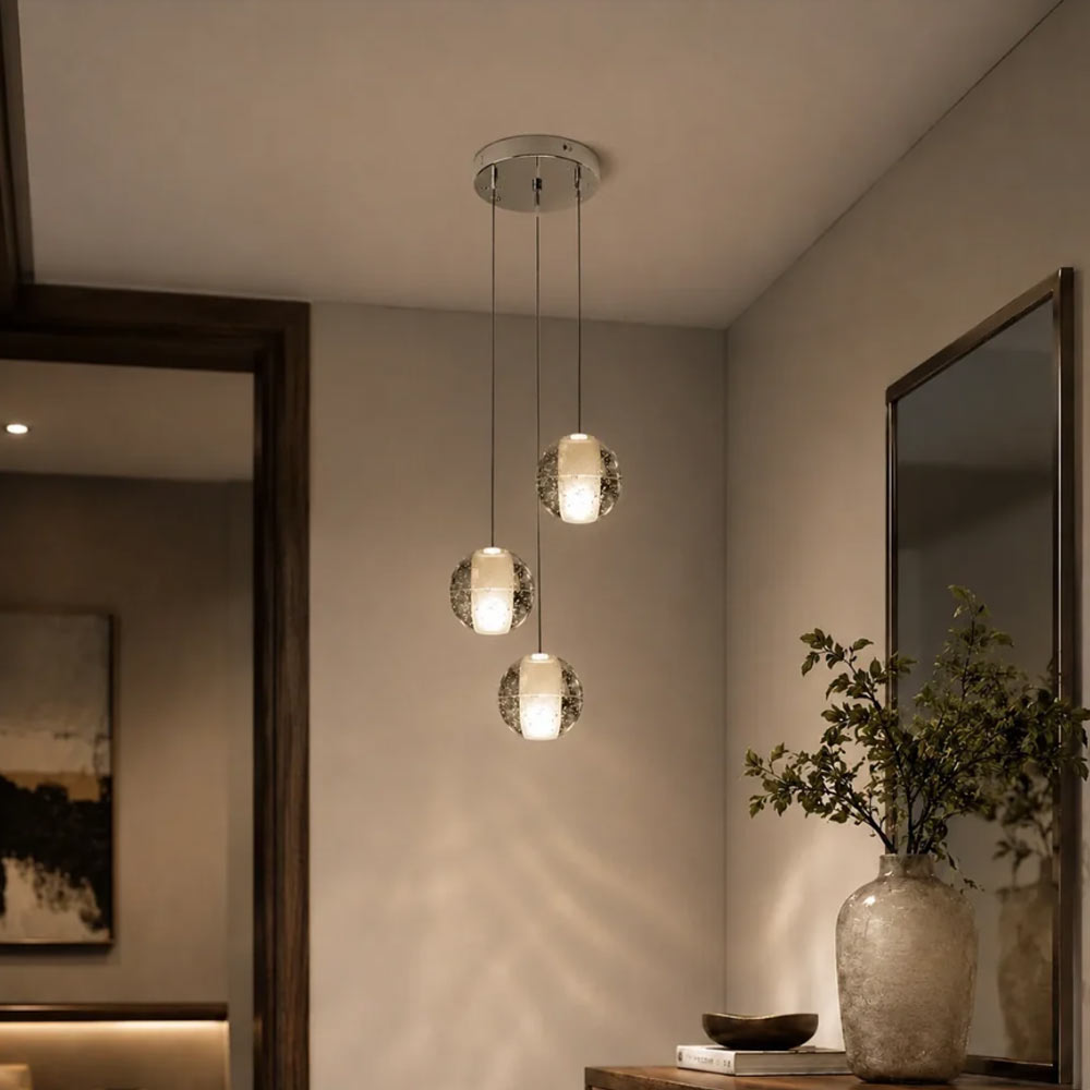 Modern 3-light crystal bubble ball pendant chandelier with round chrome canopy hanging beside bedroom console table and mirror