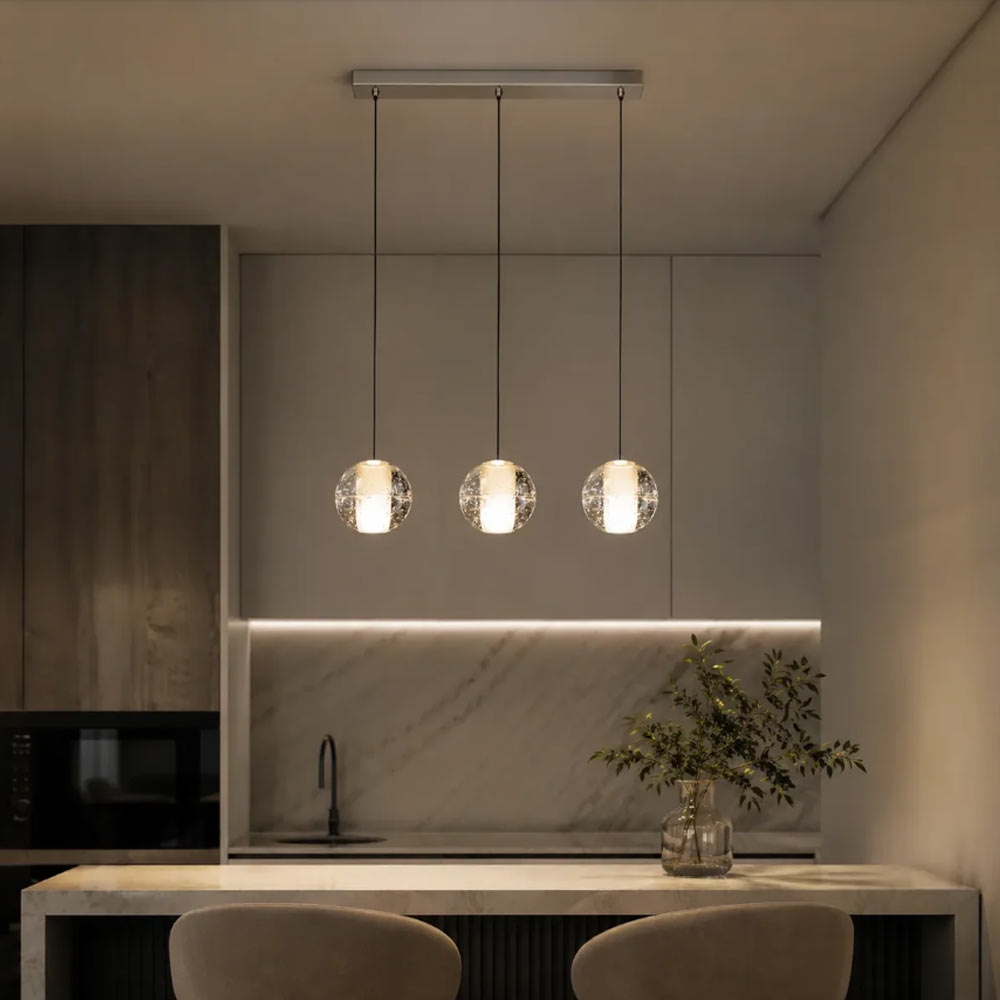 3-light linear crystal globe pendant chandelier suspended over contemporary kitchen island counter