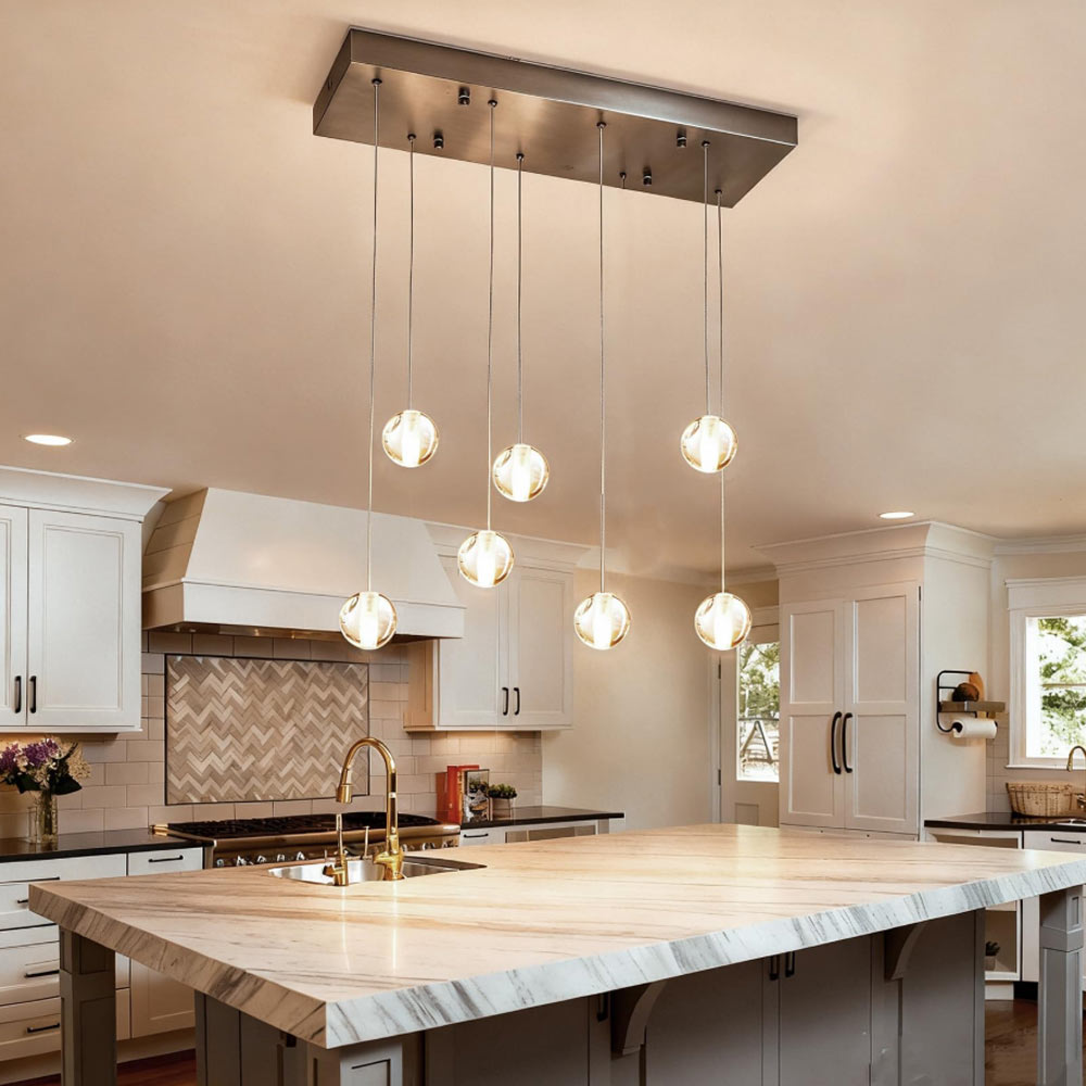 7-light staggered linear crystal globe chandelier hanging above luxury marble waterfall kitchen island