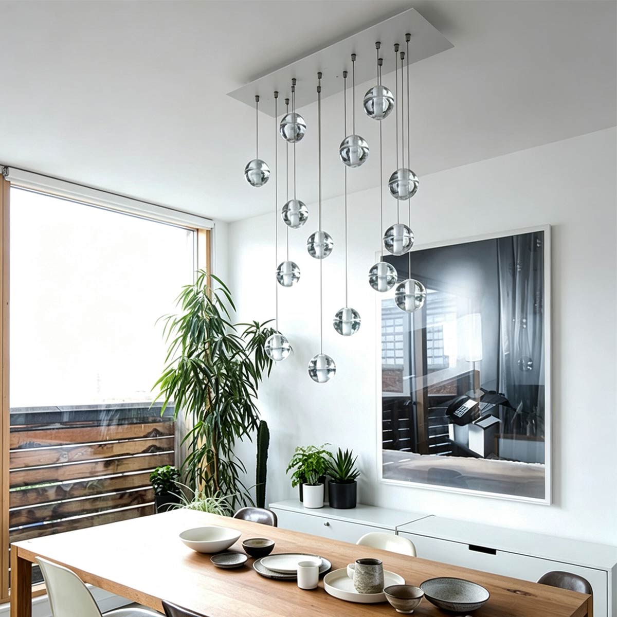 Modern linear rectangle canopy crystal ball chandelier hanging above a wooden dining table in a bright open-concept room