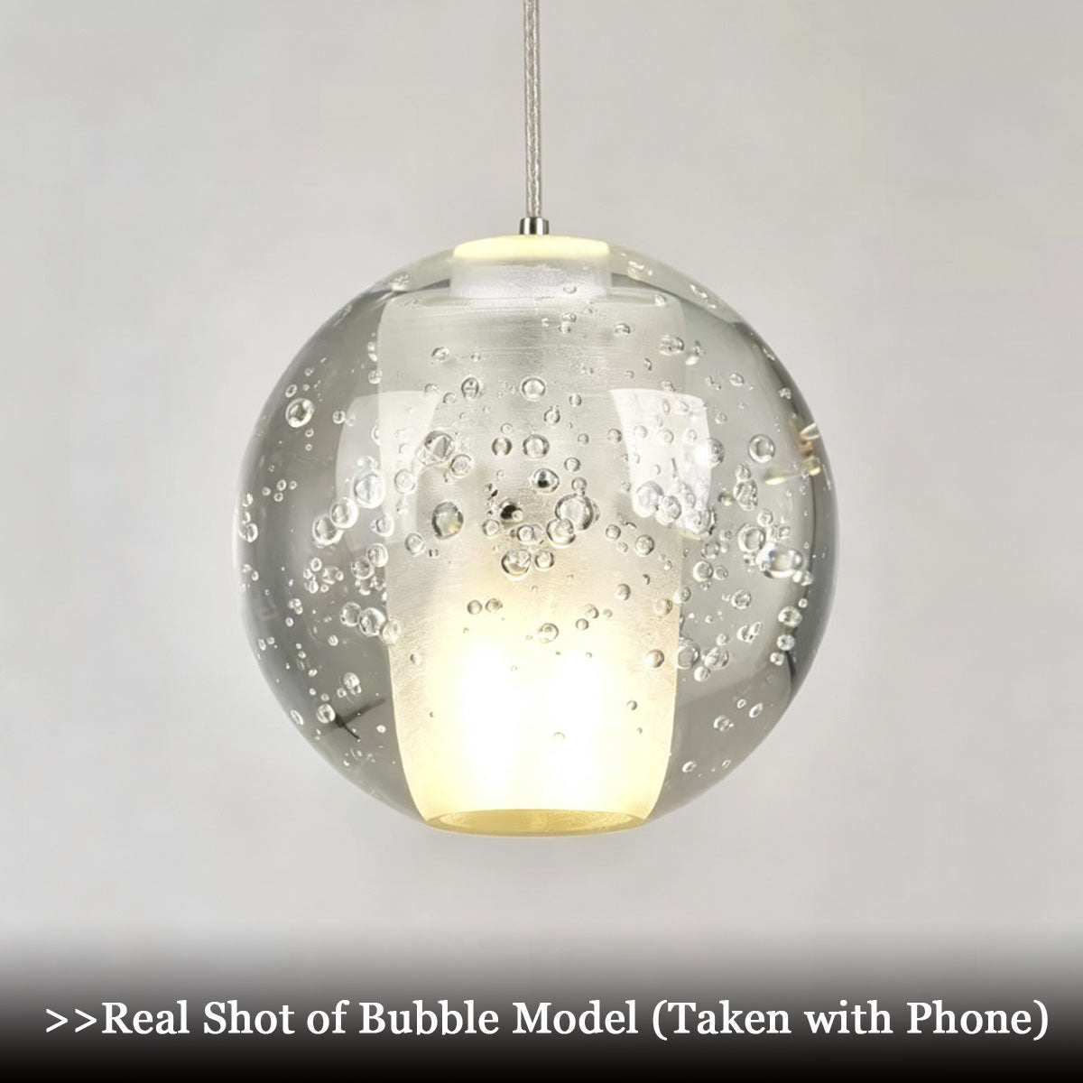Close-up unedited phone camera shot of bubble model crystal sphere showing internal frosted core and air bubble details