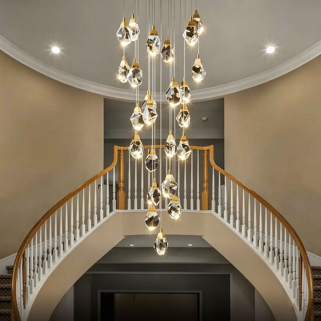 Diamond-shaped staircase chandelier with gold hardware in a grand double-height foyer