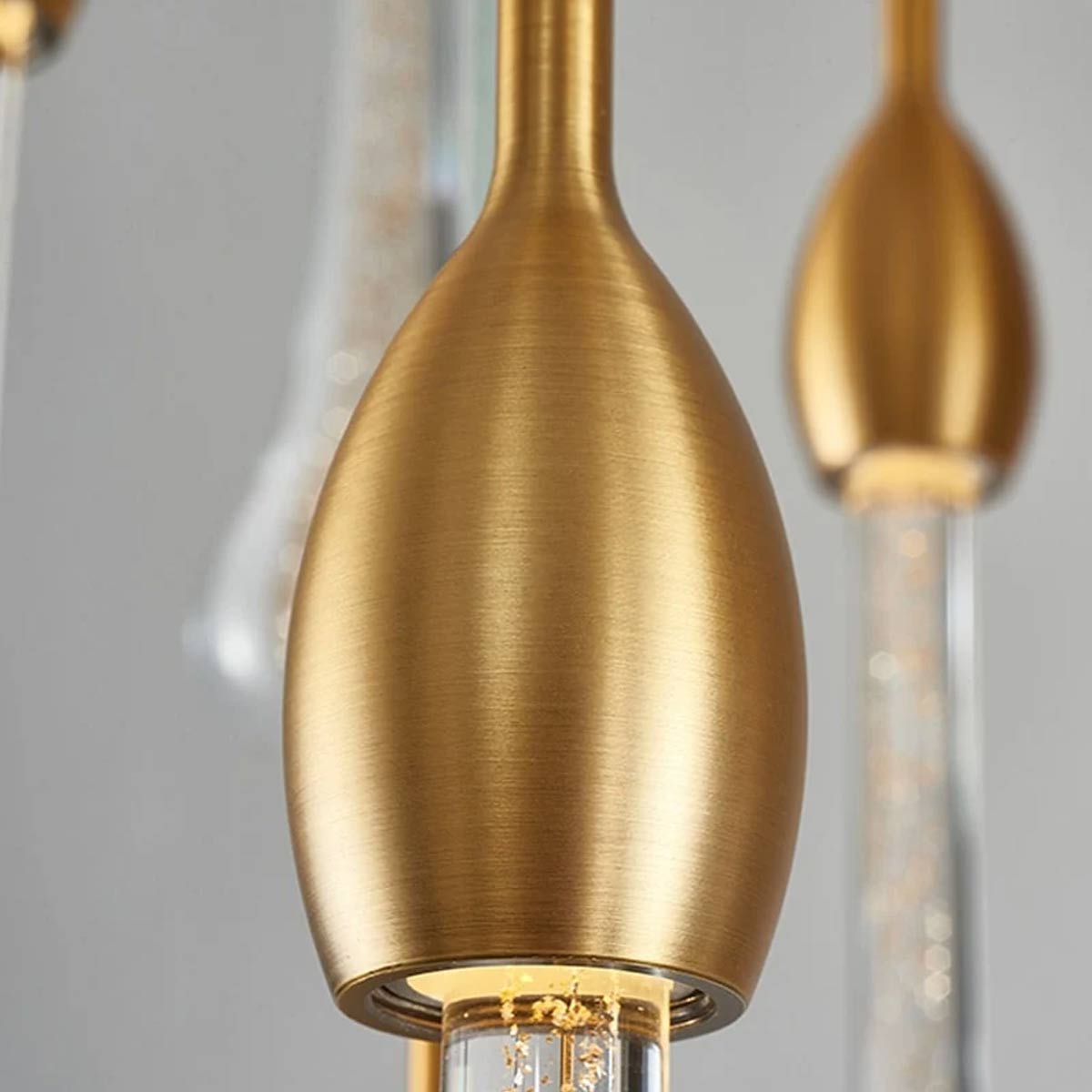Detailed close-up of brushed gold hardware and hand-blown teardrop crystal tube with gold glitter flakes