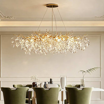 Luxury Gold Branch Crystal Chandelier installed above dining table in elegant white interior, warm ambient glow, cascading clear crystal leaf pendants on gold branch frame