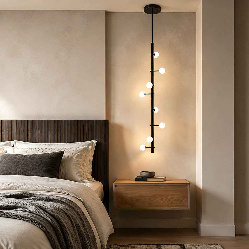 Modern black vertical linear globe glass chandelier warm lit for bedroom beside bed nightstand contemporary sleeping room home decor