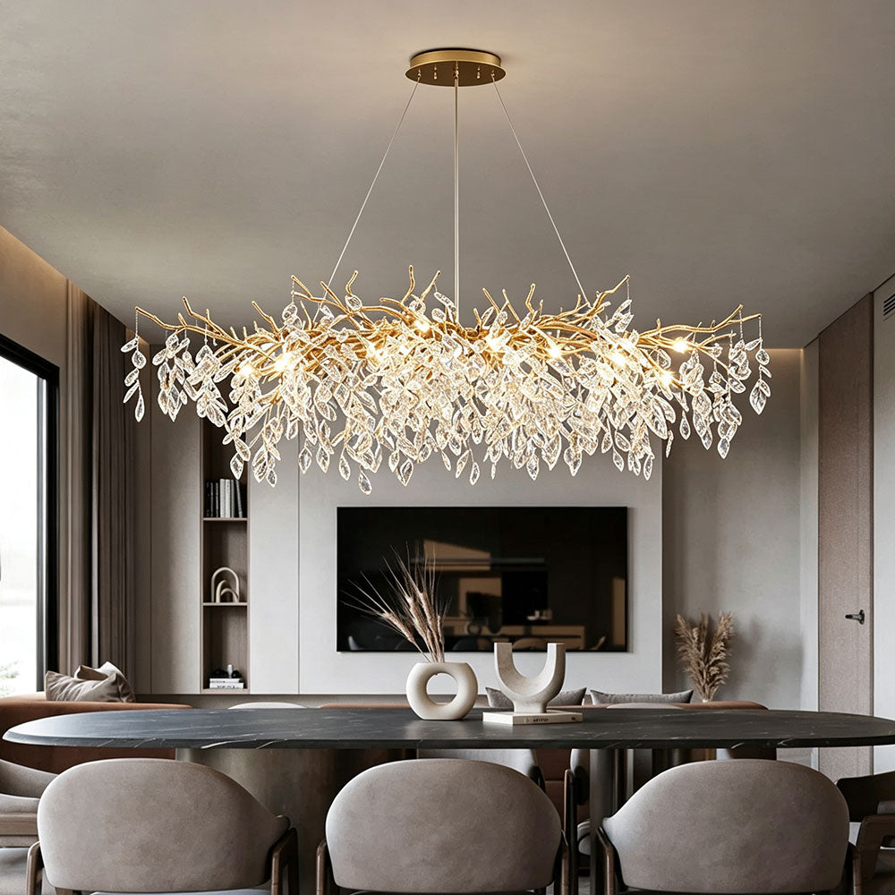 Luxury Gold Branch Crystal Chandelier installed above dining table with TV wall background, warm illuminated modern living and dining room interior, gold crystal pendant light