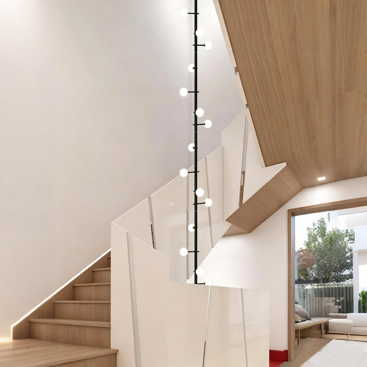 Black linear globe pendant light installed beside a modern wooden staircase